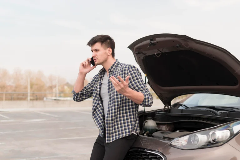 A man calling roadside assistance for car battery replacement